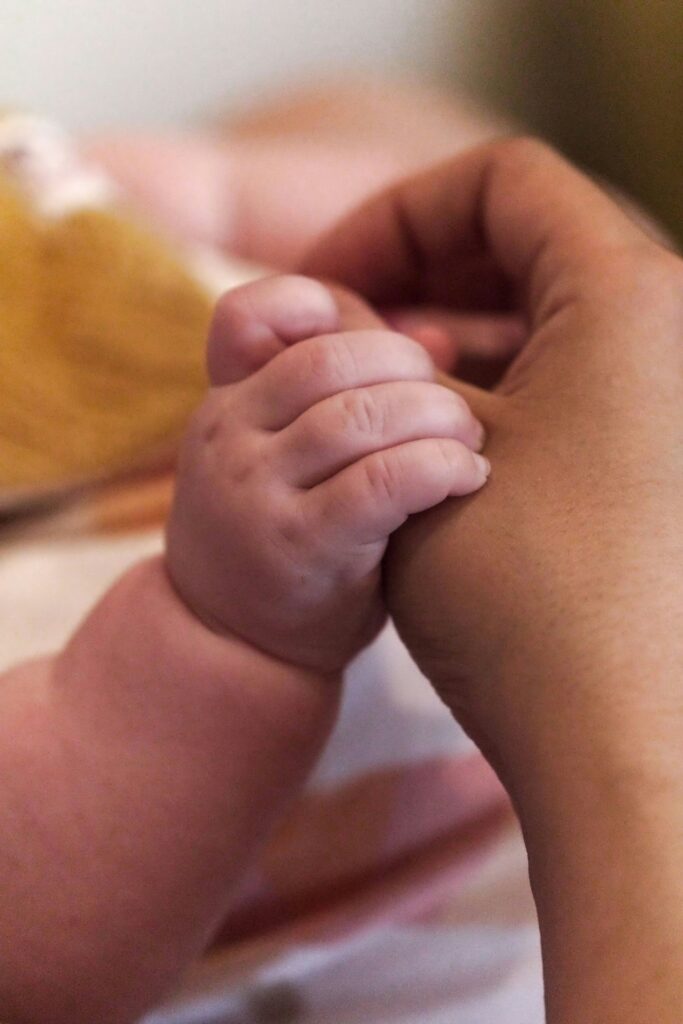 A close up of a person holding a baby's hand